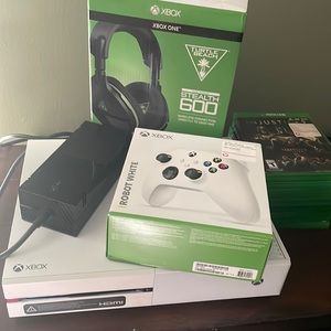 White Xbox1 with a wireless controller a headset and a couple of games